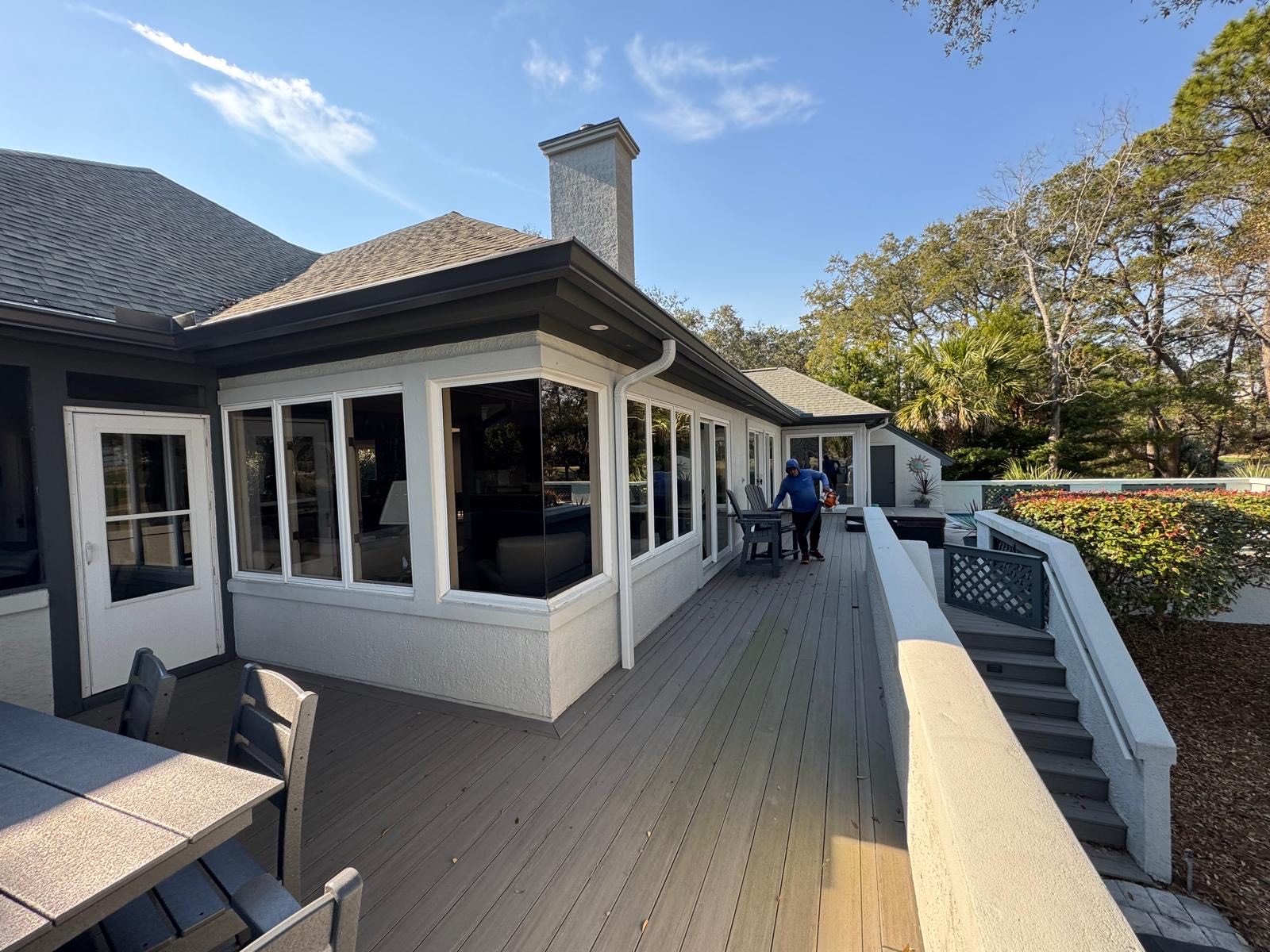 Residential home with a large outdoor deck, black gutter system, and downspouts along the roof edge
